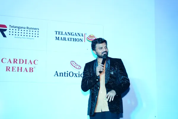 Host on stage in front of the sponsor wall