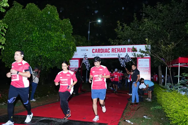 Three runners out of the lit arch in the dark