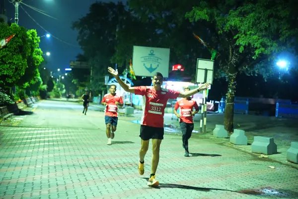 Night-lit runner with arms out
