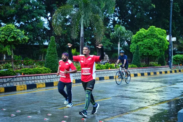 Two runners, arms up