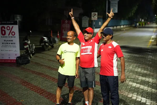 Three runners cheering beside the 6% glucose board