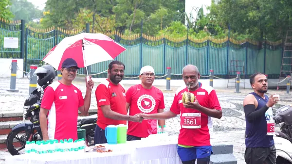 Volunteers under the umbrella handing out tender coconut