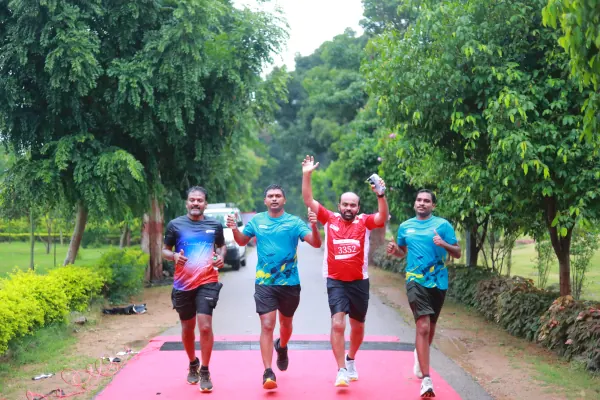 Four friends finishing together, arms raised