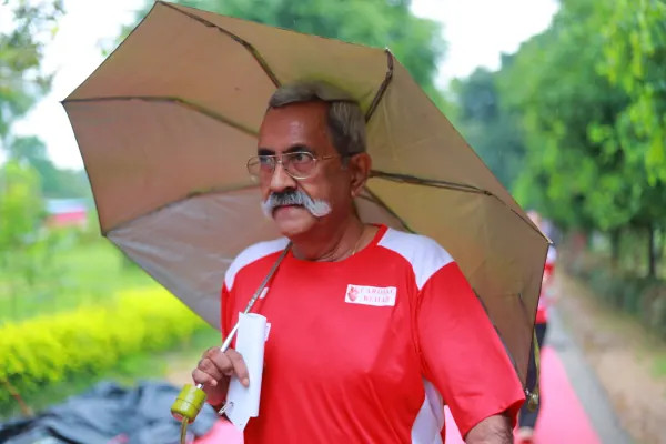 Older runner with an umbrella at the finish
