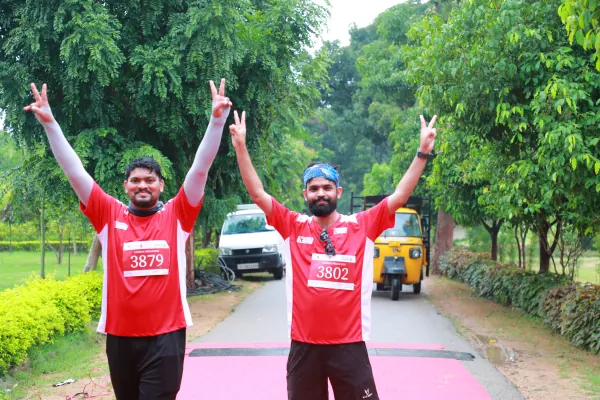 Two runners double victory signs